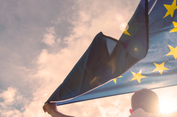 A man holds an EU flag.