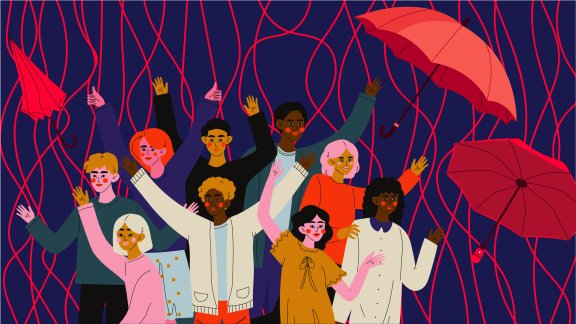 Group of diverse people surrounded by red umbrellas and red streamers.